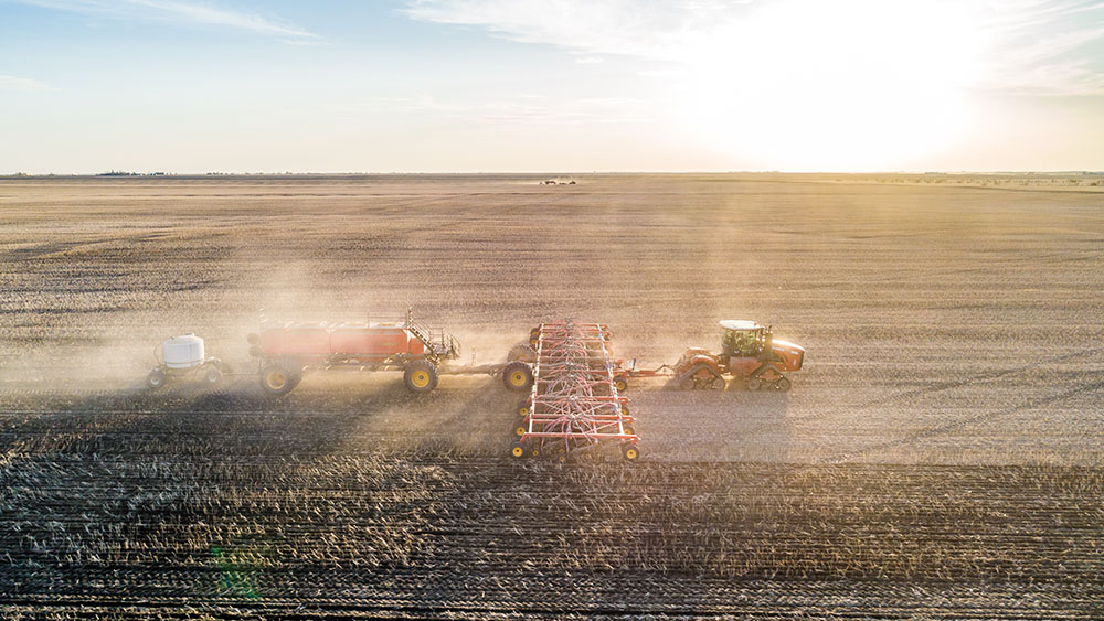 Aerial photo of a red Väderstad Seed Hawk 84 air seeder and Precision Delivery 1000 air cart in the field.
