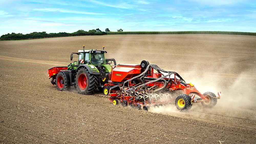 Aerial photo of a red Väderstad Proceed agricultural machine in the field.