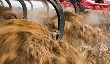 Closeup of Väderstad MixIn shins working the soil in a field