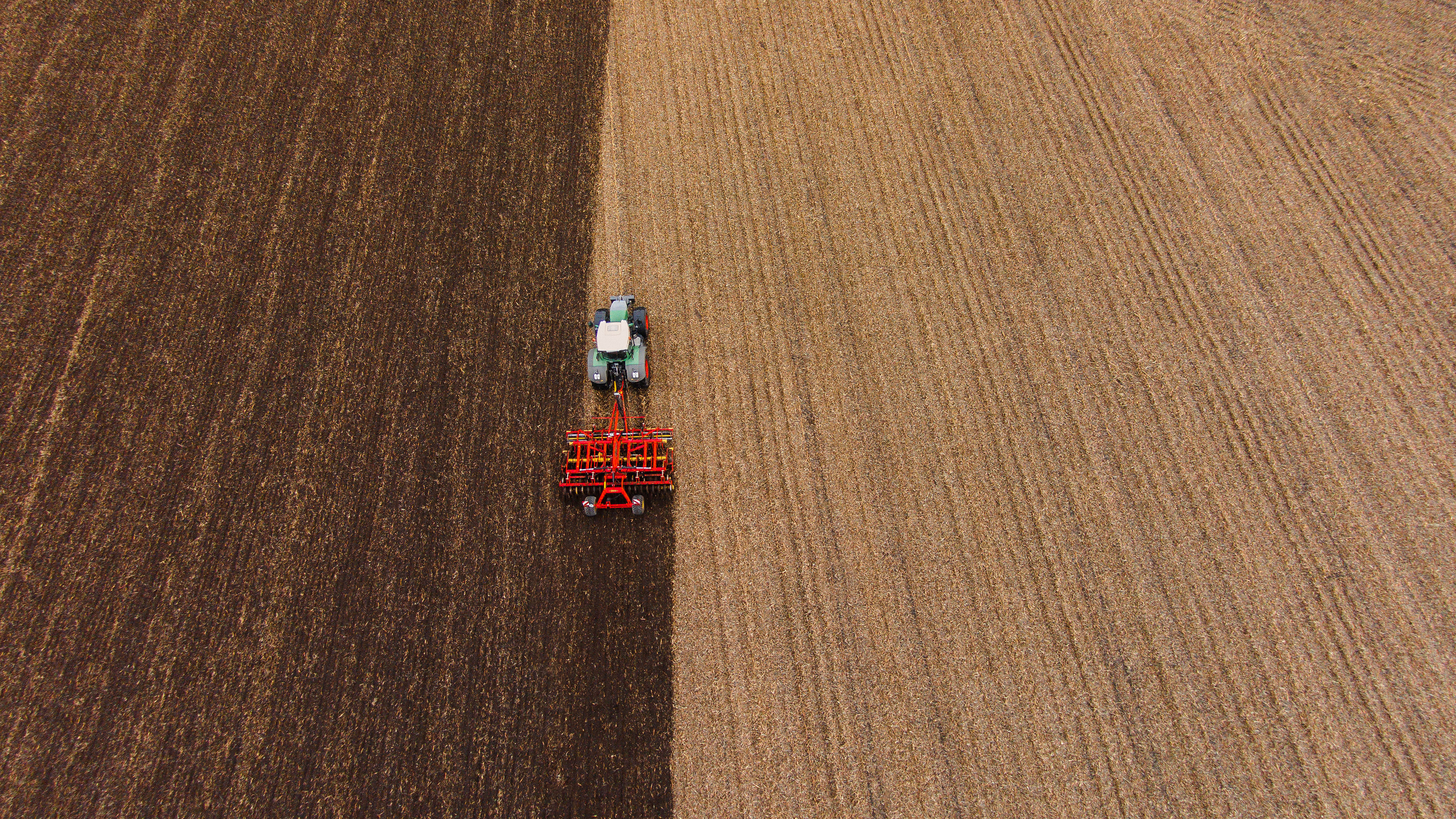 Campo con un cultivador rojo.