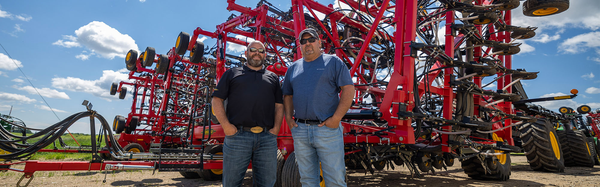 Salesman and customer standing in front of machinery